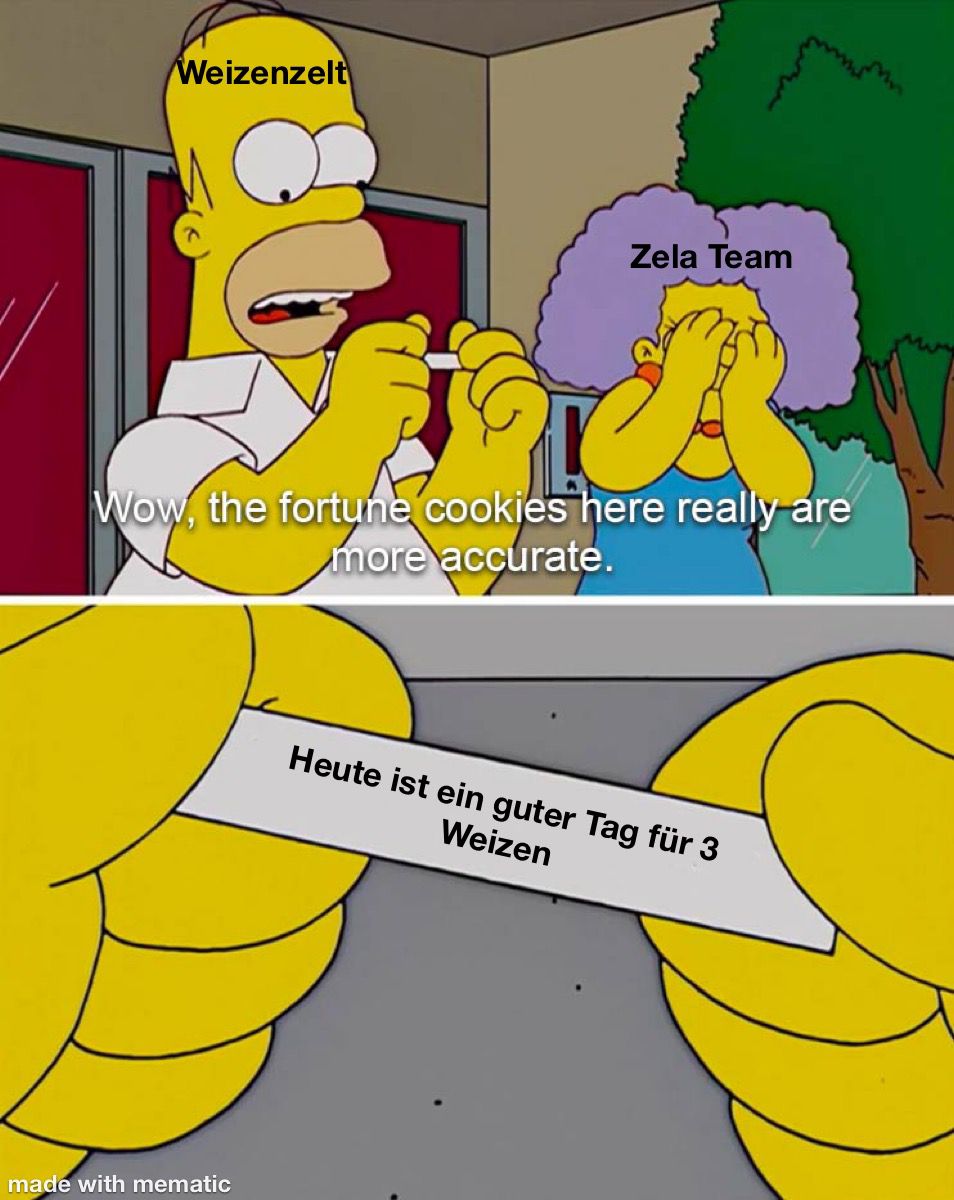 Homer, beschriftet mit "Weizenzelt", sagt "Wow, the fortune cookies here really are more accurate.", während Selma Bouvier, beschriftet mit "Zela Team", im Hintergrund ihr Gesicht in den Händen vergräbt. Auf dem Zettel des Glückskeks steht: "Heute ist ein guter Tag für 3 Weizen."